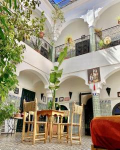 una stanza con tavolo e sedie in un edificio di Riad Sijane a Marrakech