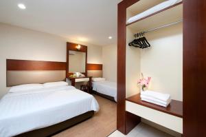 a hotel room with two beds and a mirror at Fenix Inn in Malacca