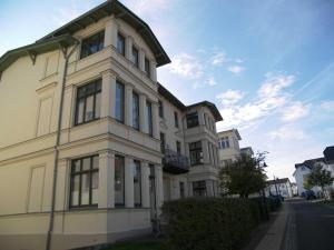 a large white building with windows on a street at Villa Goodewind 100 m zum Strand in Ahlbeck