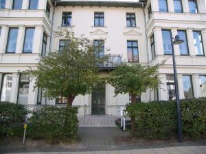 a white building with trees in front of it at Villa Goodewind 100 m zum Strand in Ahlbeck