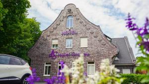 un edificio con una torre con graffiti púrpura. en dS Hotel Restaurant Gronau en Gronau