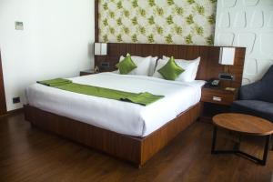 um quarto com uma cama grande e um cobertor verde em HOTEL CEASAR PALACE em Kottayam
