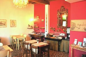 a restaurant with red walls and tables and a mirror at Relais Alcova del Doge in Mira