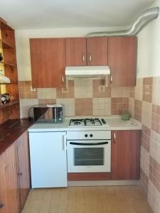 a kitchen with a white stove and brown cabinets at Apartments Luce in Kornić