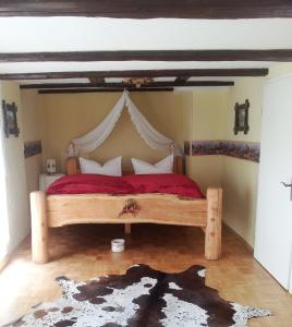 1 dormitorio con cama de madera y manta roja en Western-Inn, en Klipphausen