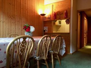 a table with chairs and a vase of flowers on it at Appartement Val d'Isère 6 personnes avec parking in Val dʼIsère