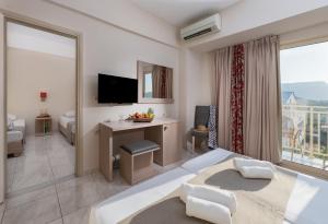 a hotel room with a bed and a desk with a television at CHC Marilena Hotel in Amoudara Herakliou