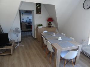 a dining room with a table and chairs and a kitchen at Coeur de Solrézis in Solre-le-Château