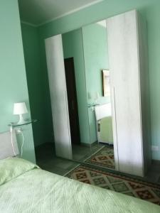 a mirror in a bedroom with a bed and a bathroom at Golfo dei poeti in Lerici