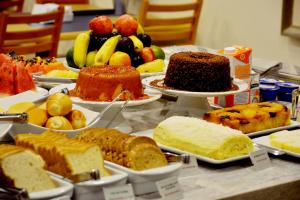 una mesa cubierta con muchos tipos diferentes de pan en Brumado Hotel en Campo Grande