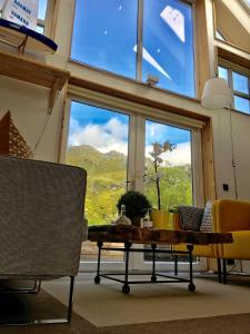 Pokój ze stołem i krzesłami oraz dużym oknem w obiekcie Lofoten Fjord Lodge w mieście Saupstad