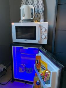 a microwave on top of a refrigerator with food in it at Good night Leuven -Self check-in in Leuven