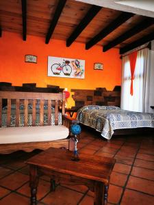 two beds in a room with orange walls and a table at Namasté Cabañas, Huasca de Ocampo in Huasca de Ocampo