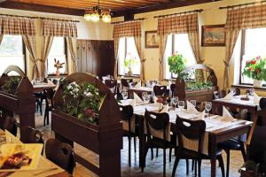 a dining room with tables and chairs and windows at Hotel Tripič, restaurant and pizzeria in Bohinj