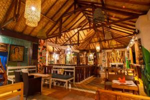 a restaurant with wooden ceilings and wooden tables and chairs at Salim Beach Resort in Gili Air