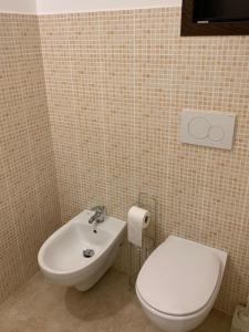 Łazienka z białą toaletą i umywalką w obiekcie Monolocale Cora w mieście Corsano