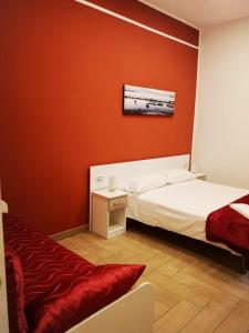 Schlafzimmer mit roten Wänden, einem Bett und einem Tisch in der Unterkunft Dimora Ruggiero in Neapel