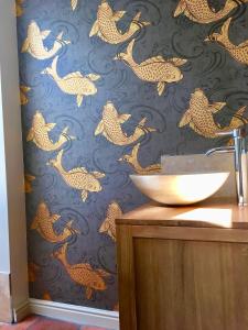 a bathroom with a wall mural of japanese fish at Fern Tree Cottage in Frome +18 photos