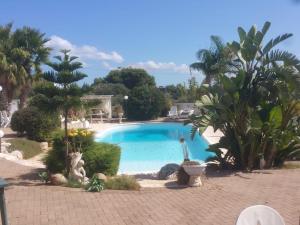 a swimming pool in a garden with a view of the water at Sole&Mare in Monopoli
