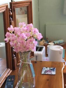 un jarrón lleno de flores rosas en una mesa en Weyside House en Weymouth