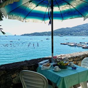 un tavolo con un cesto di frutta e un ombrello di B&B La Palafitta a Portovenere