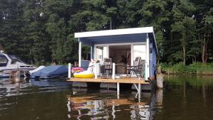 een klein huis op een dok op een waterlichaam bij Hausboot Mirabella am Müritz Nationalpark Festanliegend in Mirow