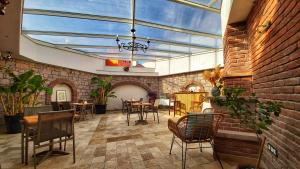 a restaurant with tables and chairs and a glass ceiling at Sukha Cunda Otel in Cunda