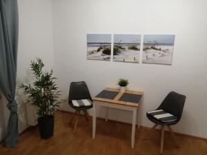ハノーファーにあるApartment zum Relaxen - ruhig und doch zentralの絵画が飾られた部屋(テーブルと椅子2脚付)
