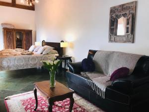 uma sala de estar com um sofá e uma cama em La Réserve Suites em Monte Verde