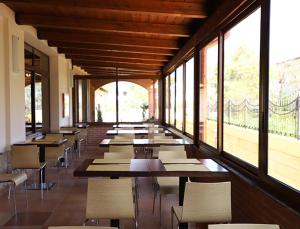 a row of tables and chairs in a room with windows at SIBARI RESORT in Sibari