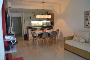 un soggiorno con tavolo, sedie e divano di Green Park 2 Ambientes en PB con Jardín y Parrillero a Punta del Este Altre 35 foto