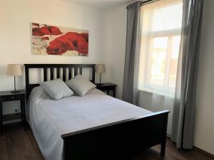 a bedroom with a bed with two pillows and a window at Cozy seaside park apartment in Liepāja