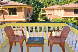 two chairs and a table on a balcony at Sonikas Leisure in Candolim