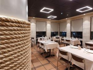 a dining room with white tables and chairs at Montemar in Llanes