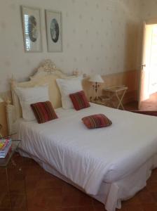 a bedroom with a large white bed with two pillows at Chateau des Poccards in Hurigny