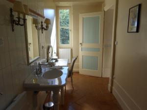 a bathroom with a sink and a mirror and a window at Chateau des Poccards in Hurigny