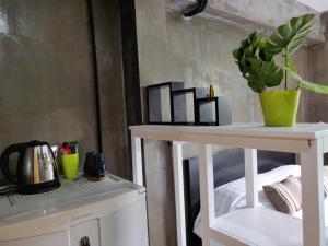 a white table with a plant on top of it at THE HOG in Bangkok Yai