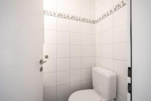La salle de bains blanche est pourvue d'une douche et de toilettes. dans l'établissement Cruscheida, à Flims