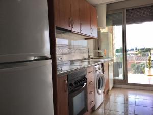 una cocina con lavadora y lavadora en Atico en Almadraba, en Benicàssim