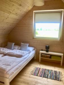 a bedroom with a bed in a log cabin with a window at Nadmorska Magia in Bobolin