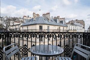 a table and chairs on a balcony with a building at Bonséjour Montmartre in Paris