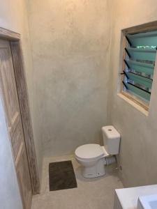 
a bathroom with a toilet and a sink at peeKAboo Diani Beach in Diani Beach
