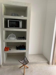 
a room with a shelf with a tv and bookshelf at peeKAboo Diani Beach in Diani Beach
