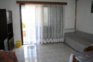 Una sala de estar con un sofá y una ventana grande. en Apartments Santa Barbara, en Biograd na Moru