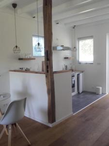 a kitchen with a table and a chair in a room at Onder de Eiken in Noord-Sleen