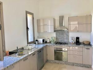 una cocina con fregadero y estufa horno superior en La Rose des Sables, en Marrakech
