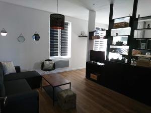 a living room with a couch and a table at La Ressourcerie du centre ville in Lens
