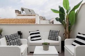 une terrasse avec des chaises, une table et une plante dans l'établissement Ancha del Carmen AVE Centro Málaga madmar lujo New Zambrano, à Malaga