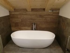 a large white bath tub in a bathroom with wooden walls at CHALET REMI-STELLA ALPINA in Livigno