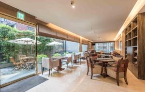 a dining room with tables and chairs and windows at Royal Biz Taipei Hotel in Taipei